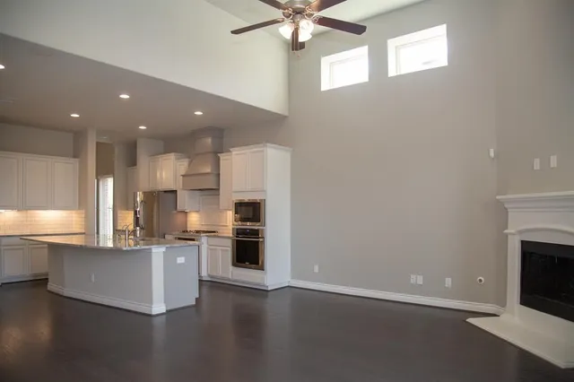 a kitchen with kitchen island granite countertop a stove top oven a sink and a refrigerator