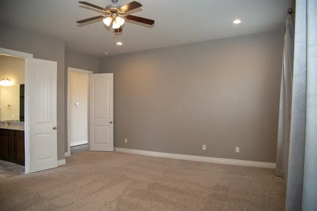 an empty room with closet and a chandelier fan