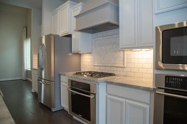 a kitchen with stainless steel appliances granite countertop a refrigerator stove and microwave