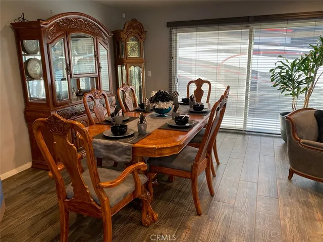 a dining room with furniture potted plants and wooden floor