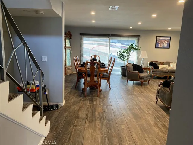 a living room with furniture floor to ceiling window and wooden floor