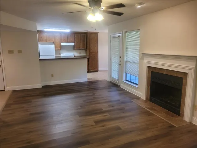 a view of a kitchen with a sink a fireplace and wooden floor