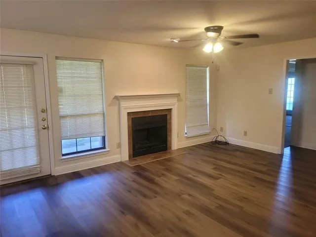 a view of a livingroom with wooden floor a fireplace and window