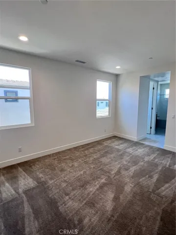 an empty room with windows and closet