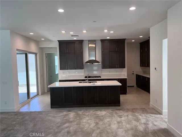 a large kitchen with kitchen island a sink stainless steel appliances and a counter top space