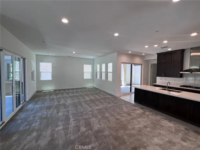 a large room with kitchen island granite countertop a stove a sink and a refrigerator