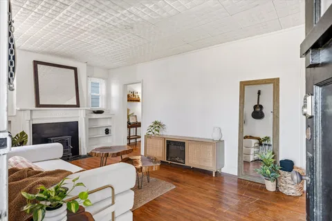 a living room with furniture a fireplace and wooden floor