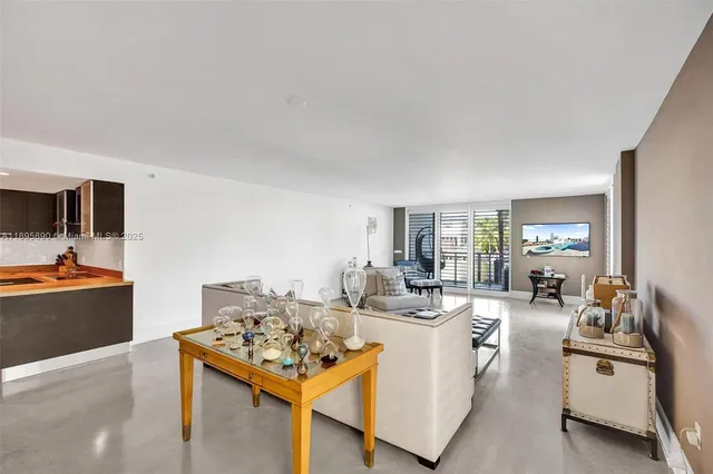 a kitchen with stainless steel appliances granite countertop a refrigerator a stove a sink a dining table and chairs