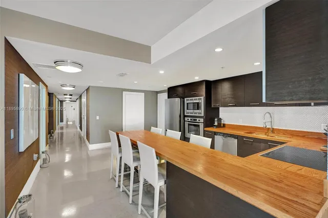 a kitchen with stainless steel appliances granite countertop a refrigerator and a sink