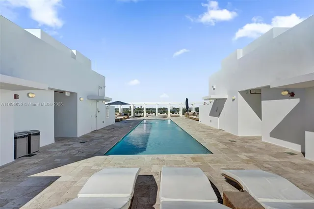 a front view of a building with a garden and plants