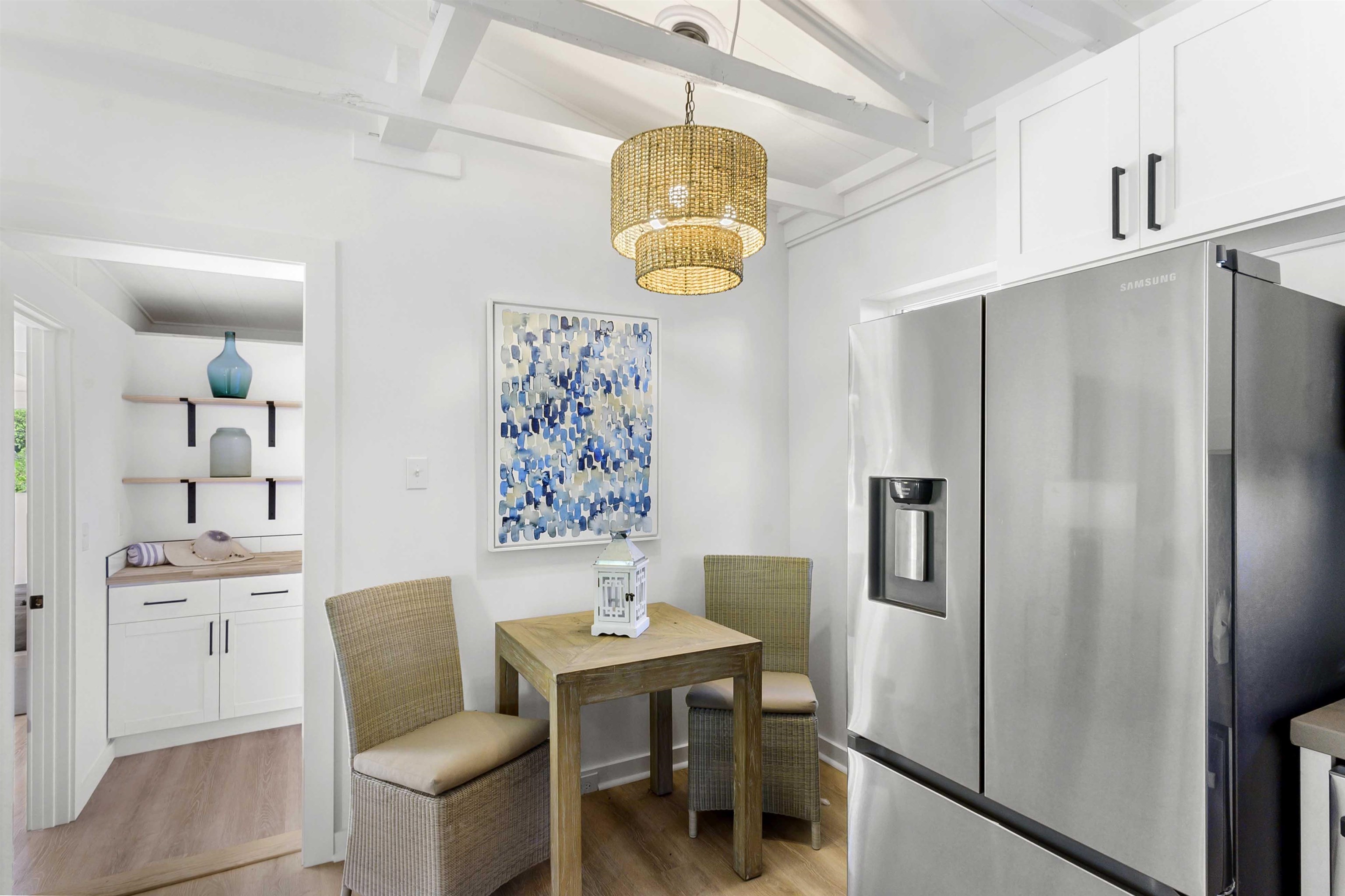 85 Honokaupu Place Haiku, HI 96708 - Photo 14 of 26 a dining room with stainless steel appliances kitchen island granite countertop a refrigerator a sink dishwasher a dining table and chairs with wooden floor