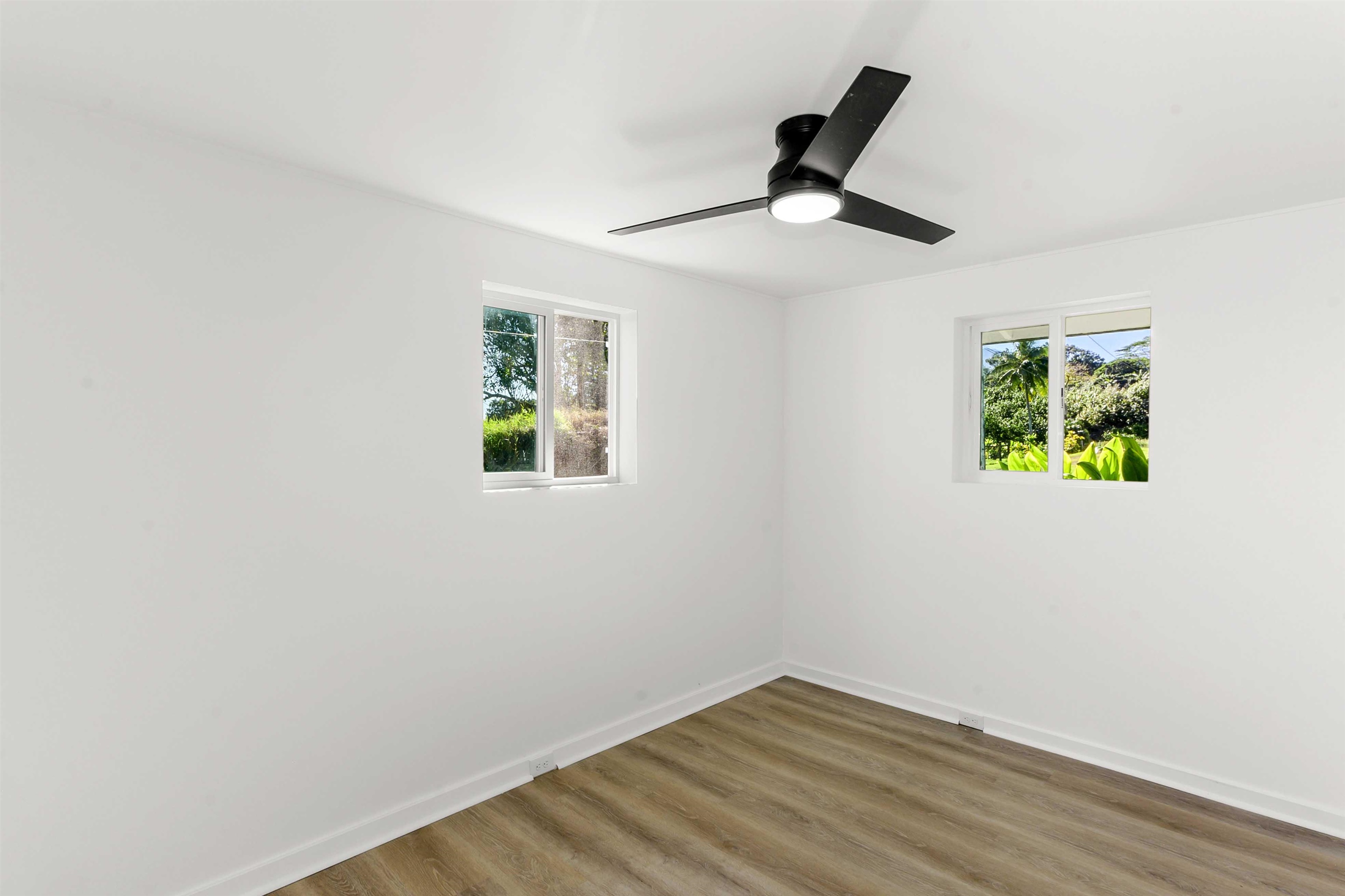 85 Honokaupu Place Haiku, HI 96708 - Photo 7 of 26 an empty room with wooden floor ceiling fan and window