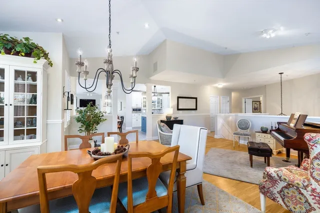 a view of a dining room with furniture a rug and wooden floor