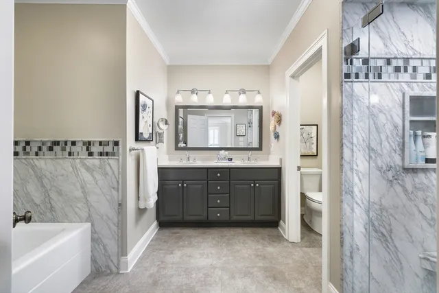 a spacious bathroom with a tub sink and mirror