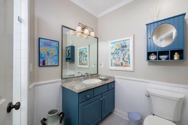 a bathroom with a granite countertop sink toilet and a mirror