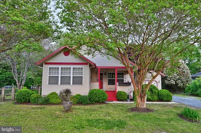 a front view of a house with a yard and trees