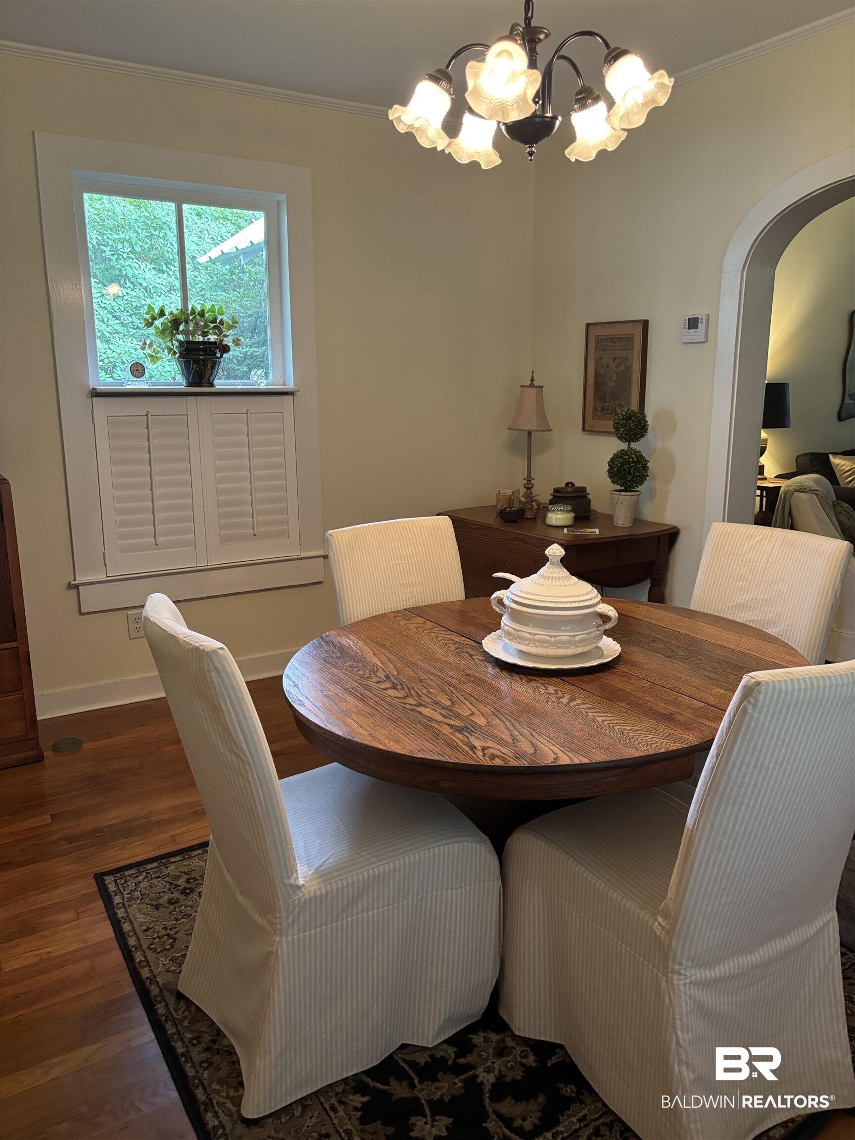 216 West Orange Avenue Foley, AL 36535 - Photo 18 of 37 Dining space with arched walkways, a chandelier, wood finished floors, crown molding, and baseboards