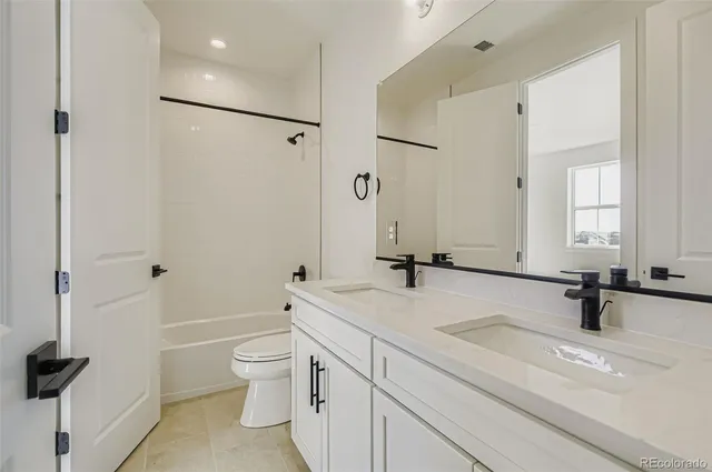 a bathroom with a sink a toilet and a large mirror