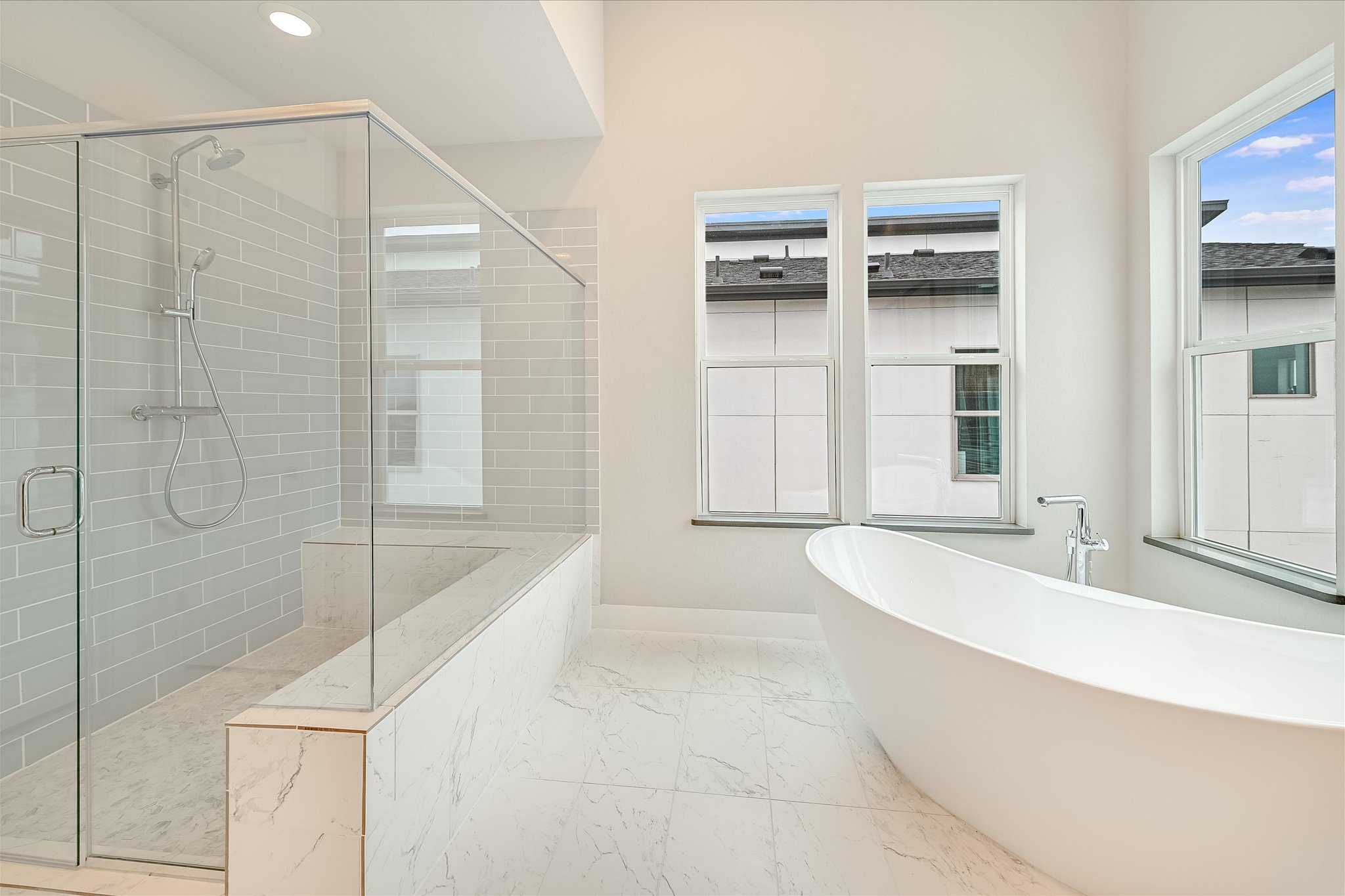 6136 Florencia Lane Austin, TX 78724 - Photo 13 of 40 Bathroom with a soaking tub, a stall shower, and light marble finish flooring