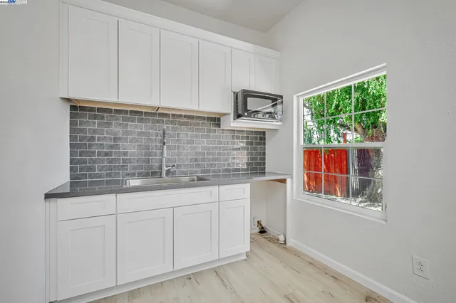 a kitchen with stainless steel appliances white cabinets and a window