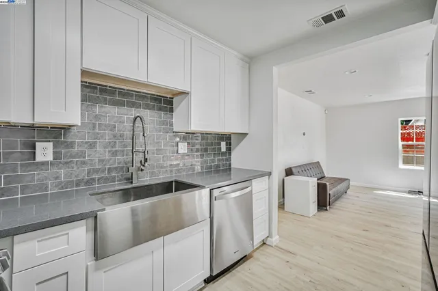 a kitchen with stainless steel appliances granite countertop a sink dishwasher stove and cabinets