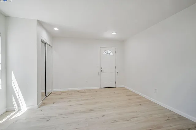 an empty room with wooden floor and sliding door