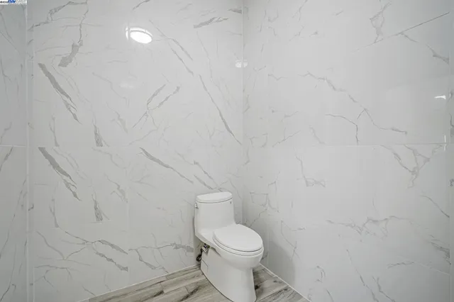 a white toilet sitting next to a white wall