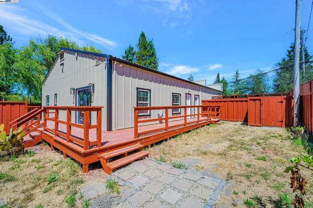 a backyard of a house with wooden floor and fence