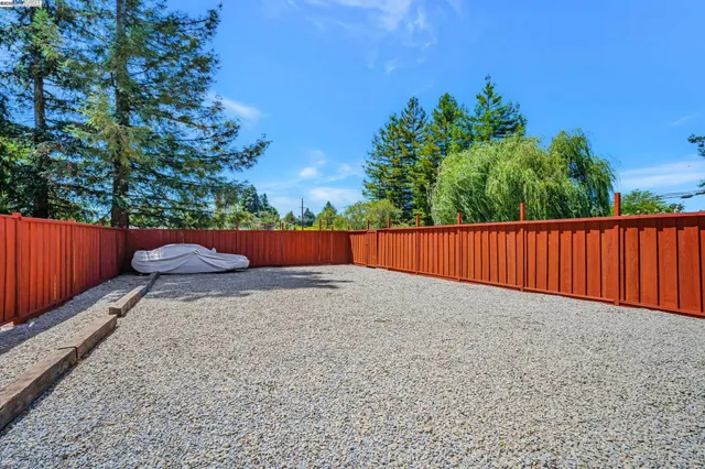 a view of a white house with wooden fence