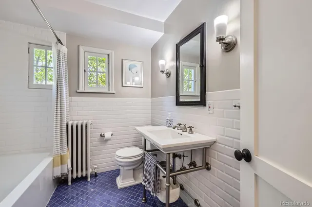 a bathroom with a sink a toilet and a mirror