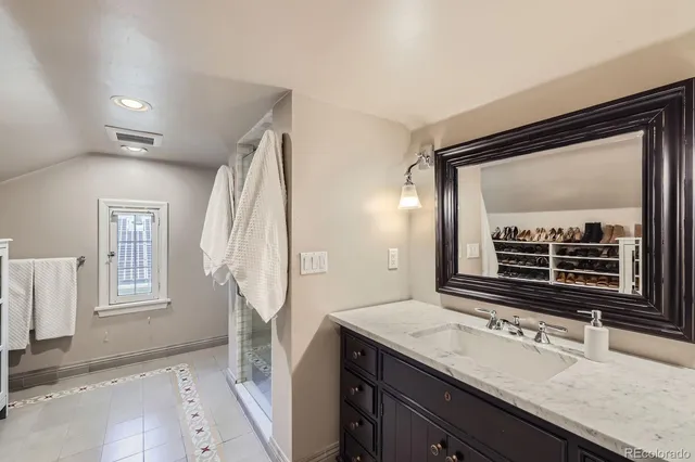 a bathroom with a granite countertop sink and a mirror
