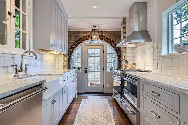 a kitchen with granite countertop a sink stove and cabinets