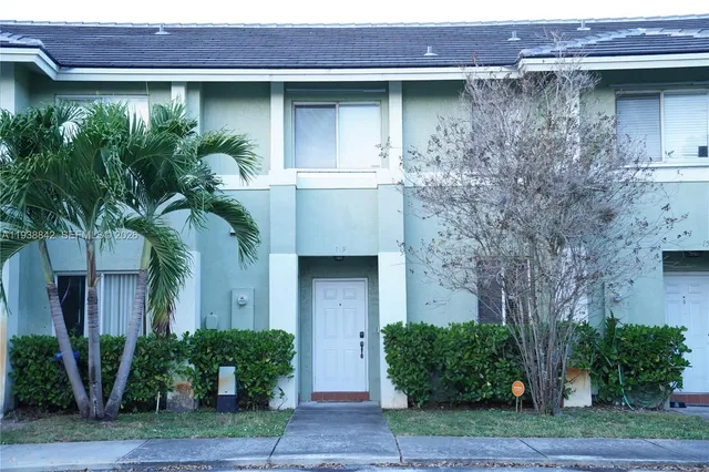 a front view of a house with plants