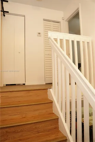 a view of a door with wooden floor and white walls