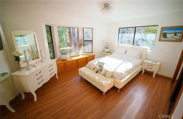 a bedroom with a bed wooden floor and window