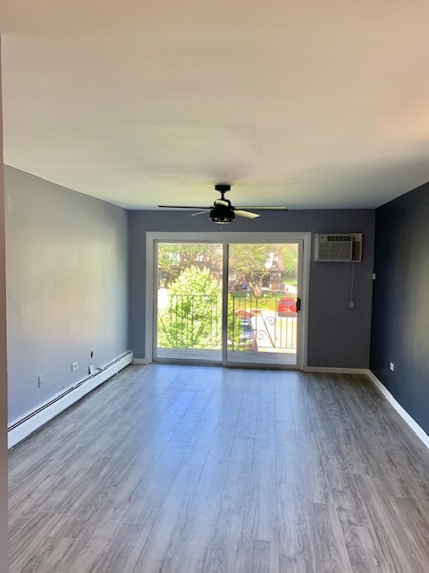 879 Trace Drive, Unit 202 Buffalo Grove, IL 60089 - Photo 3 of 18 an empty room with wooden floor and windows