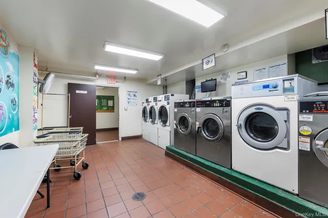 a utility room with dryer washer and a view of living room