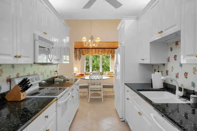 a kitchen with granite countertop a sink a stove and cabinets