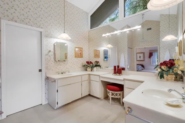 a bedroom with two beds and a lamp on the dresser