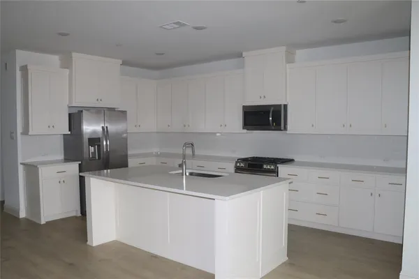 a kitchen with appliances a sink and cabinets