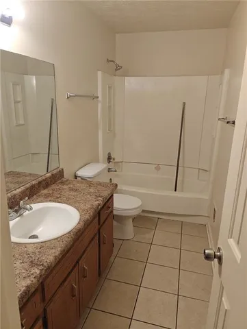 a bathroom with a granite countertop sink a toilet and shower