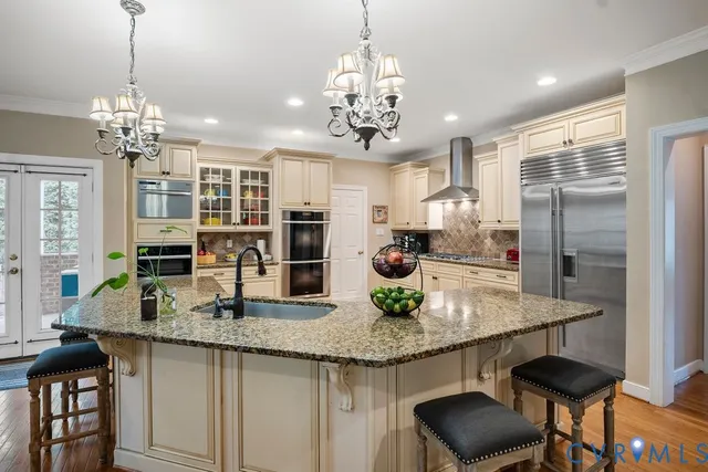 a large kitchen with kitchen island a large window and chairs