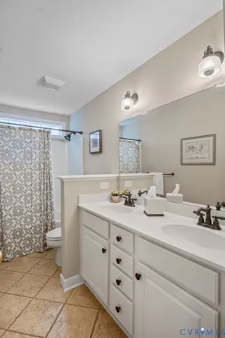 a bathroom with a granite countertop double vanity sink and mirror