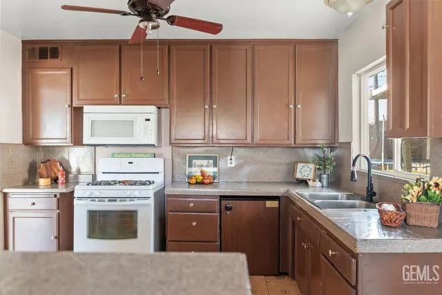 a kitchen with stainless steel appliances granite countertop a sink cabinets and stove top oven