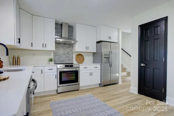 a kitchen with stainless steel appliances granite countertop a refrigerator stove and sink