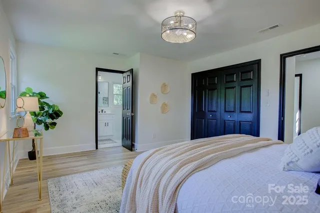 a bedroom with a large bed and a chandelier