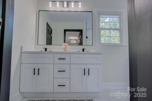 a bathroom with a double vanity sink mirror and