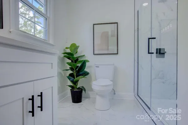 a white toilet sitting next to a bathroom