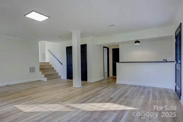 a view of a hallway with wooden floor and entryway