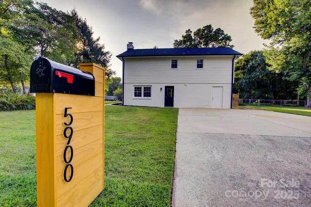 a view of a house with a yard and a potted plant